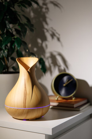 Aroma oil diffuser in the form of a jug on the bedside table