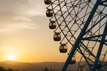 Ferris wheel in Mtatsminda amusement park in Tbilisi, Georgia. Giant wheel at sunset