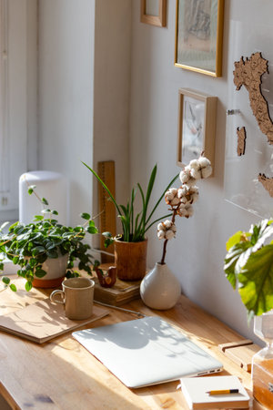 Freelancer working place - wooden desktop, laptop, houseplants, sketchbook, book, notebook, picture...