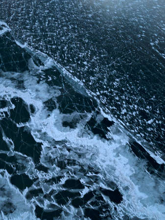 Aerial photo of frozen Baikal lake in winter in Olkhon island, in Russia. White ice cracks on dark blue frozen lake.の写真素材