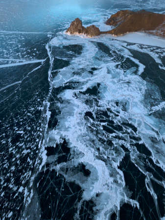 Aerial sunset image of Shamanka rock on frozen Baikal lake on Olkhon island in winter. Beautiful...