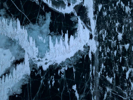 Aerial photo of frozen Baikal lake in winter in Olkhon island, in Russia. White ice cracks on dark...