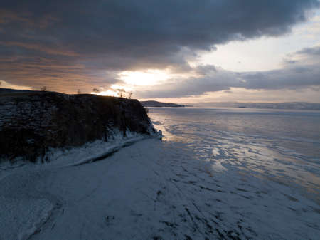 Aerial photo of frozen Baikal lake in winter on sunset. Olkhon island. Russia.