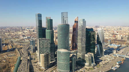 Moscow City from drone in spring sunny day. Birdâ€™s eye view. Cars goes on the highway near...