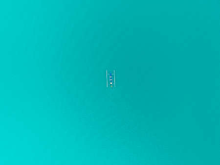 Lonely boat sailing in dark water, lake, sea, ocean. Image from drone. View from up. Bali, Indonesia.の写真素材