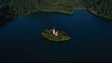 Aerial view of small island with Church of assumption of Mary in the middle of Lake Bled, Slovenia....