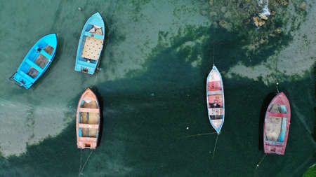 Aerial top down view of colorful fishing boats moored near the shore of Bolata cove on Black sea,...