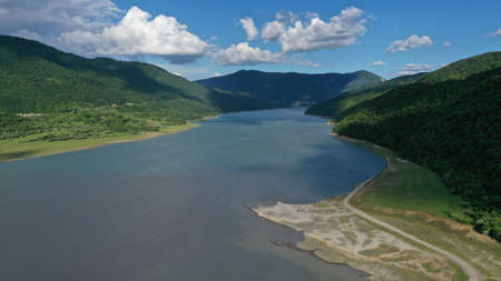 Aerial view of Ananuri landscape with green mountains, Aragvi river, trees near fortress and church....