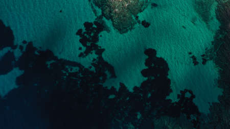 Aerial view of Aegean sea, turquoise water surface, Vourvourou beach, Kavourotripes beach, Sithonia peninsula, Halkidiki, Greece. Rocks, stones underwater.の写真素材