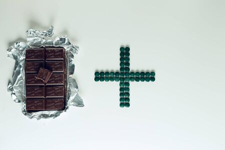Chocolate and pills on a whiteの写真素材