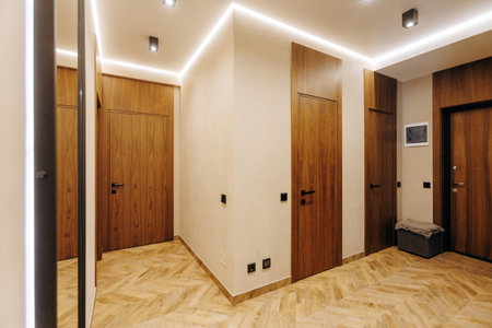 The modern hallway features elegant wooden doors and soft lighting that enhance its charmの写真素材