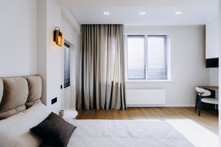 A modern bedroom with natural light and elegant decor, blending comfort and styleの写真素材