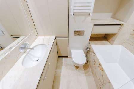 A fully furnished bathroom featuring a toilet, sink, and bathtubの写真素材