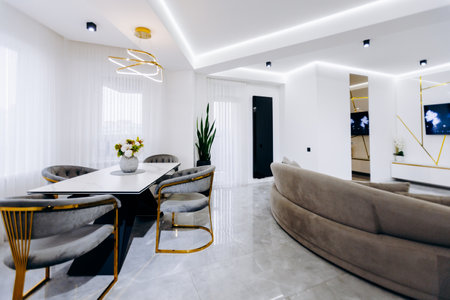A cozy living room featuring a dining table, chairs, and a spacious couchの写真素材