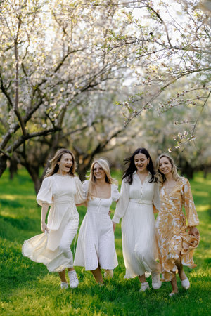 Women in beautiful white dresses walk gracefully in a parkの写真素材