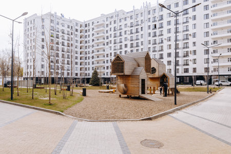 A large white building has a playground in front of itの写真素材