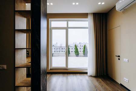 There exists an empty room that features a large window and a balconyの写真素材