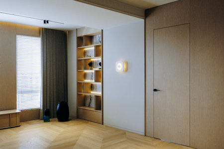 Cozy living room with wooden floor, shelves, and natural lightの写真素材