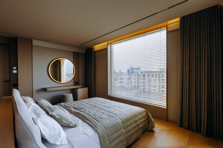The spacious bedroom has a large comfortable bed and a big windowの写真素材
