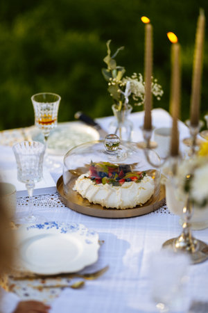 A beautifully set table featuring plates, candles, and a cake placed on itの写真素材