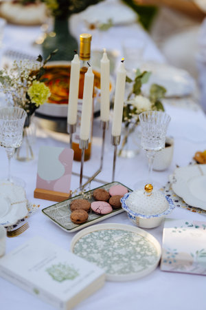 A table set with plates, candles, flowers, and an intriguing bookの写真素材