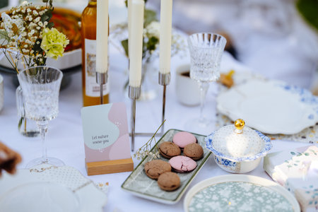 A beautifully set table with plates, candles, and cookiesの写真素材