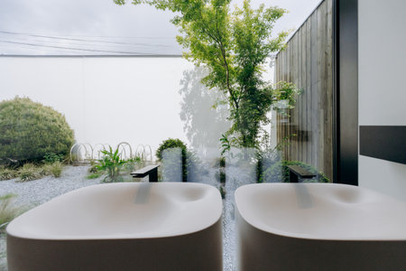 A beautifully designed bathroom features two sinks and a garden viewの写真素材