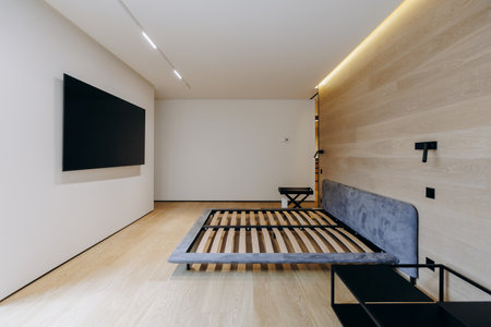 A cozy bedroom with a comfortable bed and a mounted flat screen TVの写真素材
