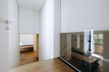A hallway in a house with white walls and a wooden floorの写真素材
