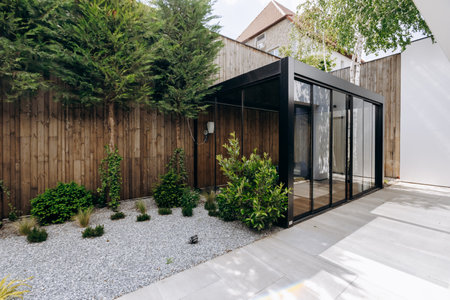 A modern house features a large glass wall and wooden fenceの写真素材