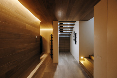 A hallway featuring a wooden ceiling and a set of stairs leading upの写真素材