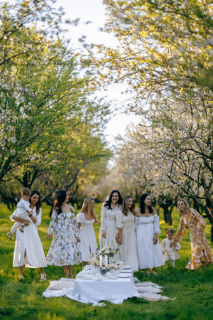 Women in elegant white dresses stand peacefully in a parkの写真素材