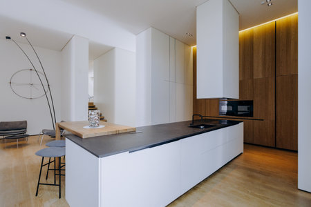 A beautiful kitchen with a black countertop and elegant white cabinetsの写真素材