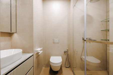 A bathroom that includes a toilet, a sink, and a shower areaの写真素材