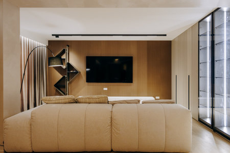 A spacious living room with a comfy couch and large wall TVの写真素材