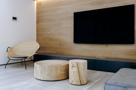 A living room with two wooden tables and a flatscreen TVの写真素材