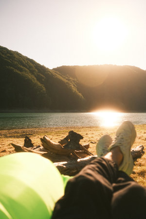 A person is relaxing on a beach, feet up, enjoying the sunの写真素材