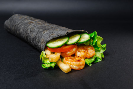 A wrap with shrimp, lettuce, tomatoes, and cucumbersの写真素材
