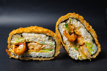 Two sushi pieces with shrimp and avocado on a black backgroundの写真素材