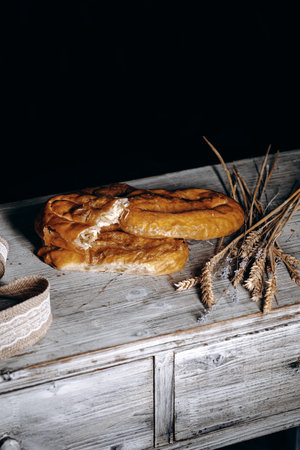 Artisan Bread and Wheat on a Rustic Table Surrounded by Nature and Ingredients for Bakingの写真素材
