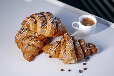 Savor the Flavor of Delicious Croissants Served with Rich Coffee and Tasty Chocolate Drizzleの写真素材