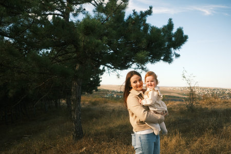 A Mother Tenderly Embracing Her Child in the Beautiful Embrace of Natures Splendorの写真素材