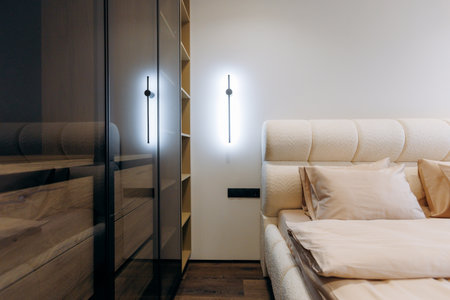 A Modern Minimalist Bedroom Featuring Elegant Lighting and Sleek, Contemporary Furnitureの写真素材