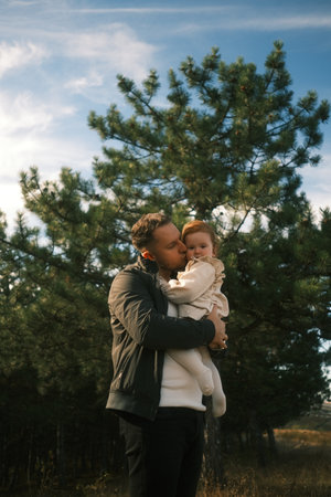 A Father Embracing His Child in a Beautiful and Serene Nature Setting Surrounded by Fresh Airの写真素材