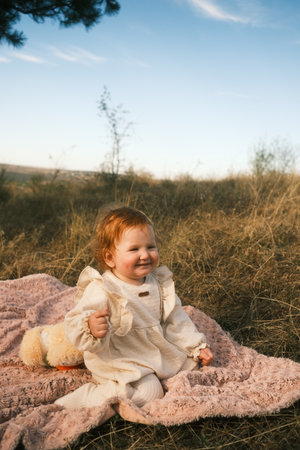 A Happy Child Enjoys the Beauty of Nature Comfortably Relaxing on a Blanket Outdoorsの写真素材