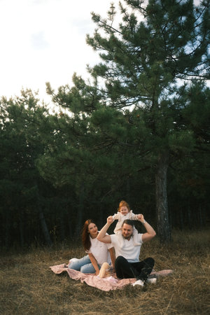 Enjoy a joyful Family Picnic in Natures beauty beneath Tall Pine Trees, bonding and happinessの写真素材