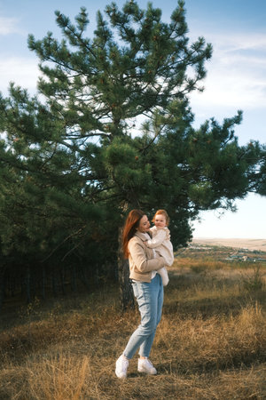 Mother and Child Embracing in Nature, symbolizing their deep bond and joyful moments togetherの写真素材
