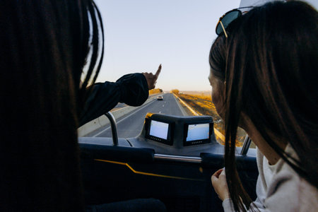 Two women sharing joyful moments during coastal journeyの写真素材
