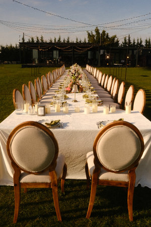 banquet scene with warm lighting, refined event space illuminated by candles and sunset backdrop