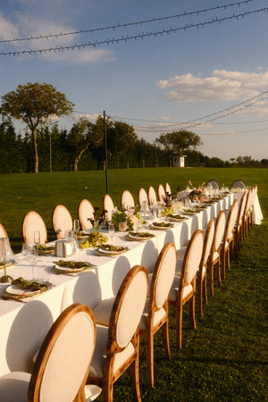 charming outdoor gathering, refined event arrangement with charming chairs and sunset illuminationの写真素材